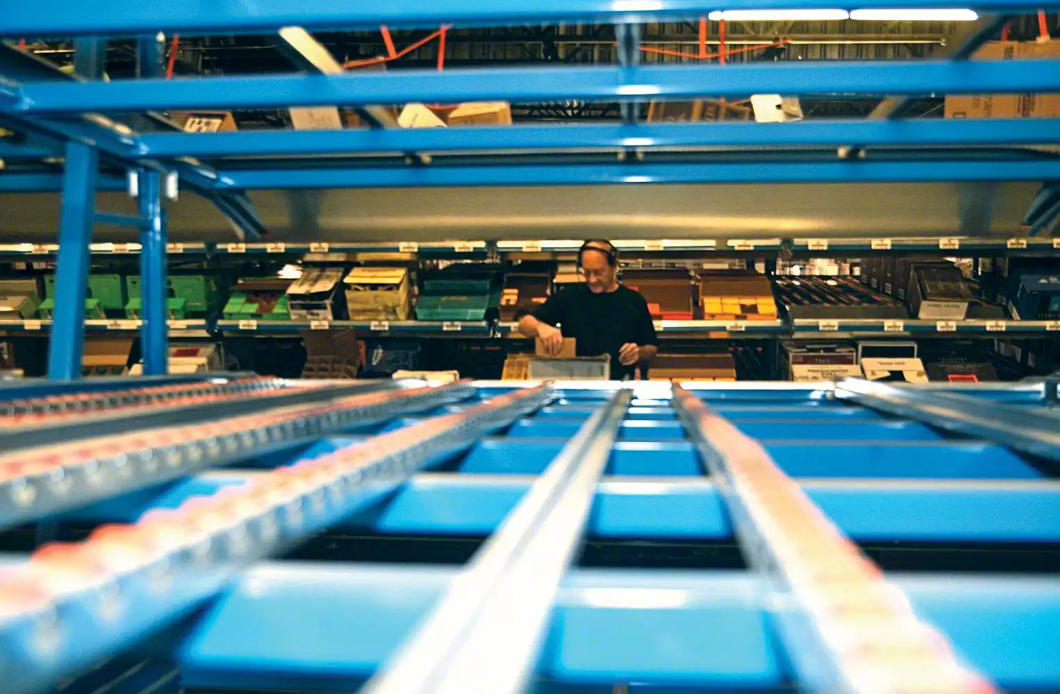 Carton flow rack lane with wheel bed rollers