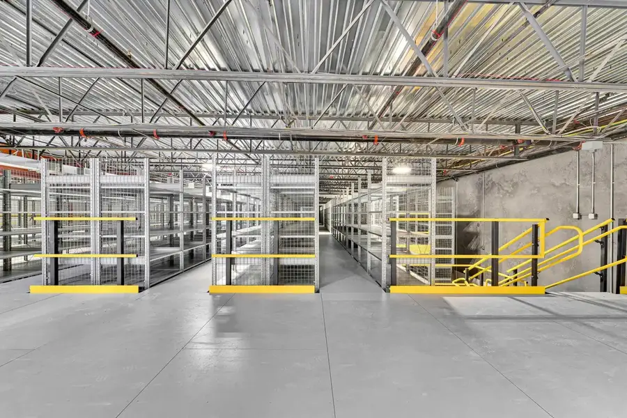 Mezzanine with pallet drop zone and safety gate