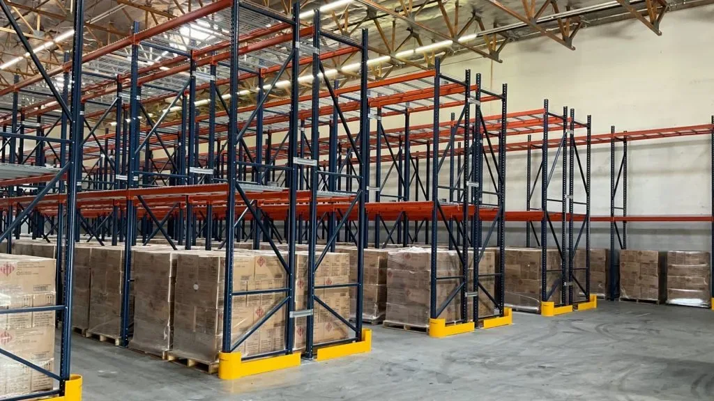 Floor-mounted safety bollards in warehouse aisle